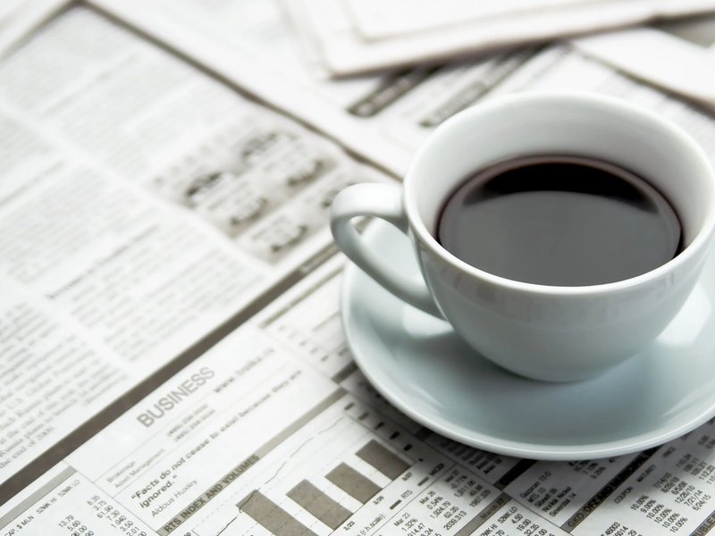 A cup of coffee on the newspaper from Home Floor Covering and Polson Stone and Tile in Polson, MT
